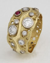 Large 'Pierced Ring' in 18K gold with diamonds and single Ruby 